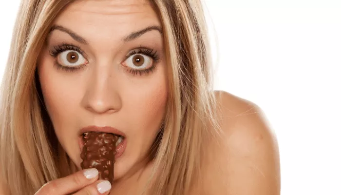 mulher comendo chocolate e curiosa